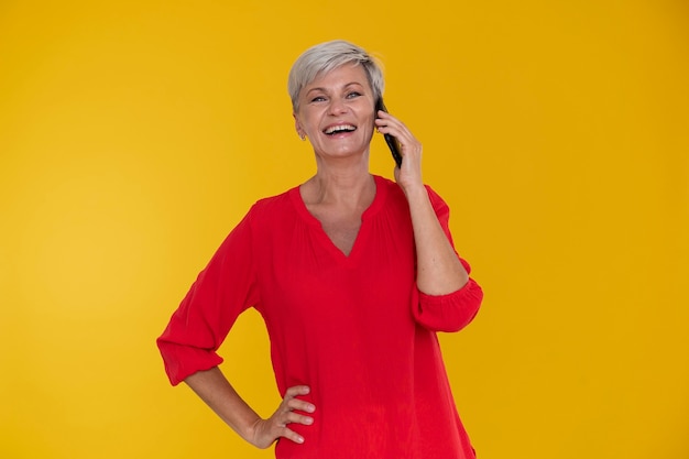 Porträt einer stilvollen älteren Frau, die am Telefon spricht