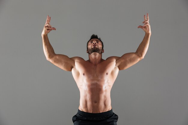Porträt einer überzeugten starken hemdlosen männlichen Bodybuilderaufstellung