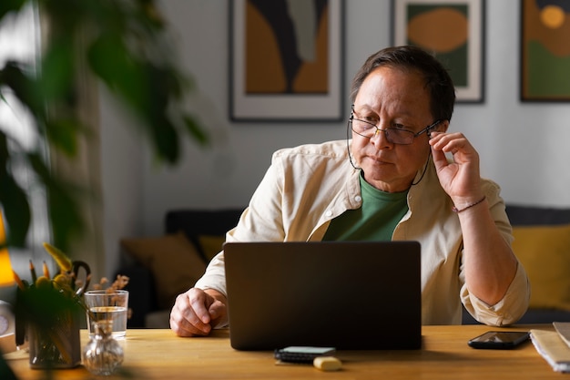 Porträt eines älteren Mannes, der zu Hause einen Laptop benutzt