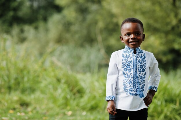 Porträt eines afrikanischen Jungenkindes in traditioneller Kleidung im Park
