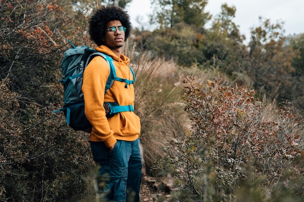 Kostenloses Foto porträt eines afrikanischen männlichen wanderers, der im wald wandert