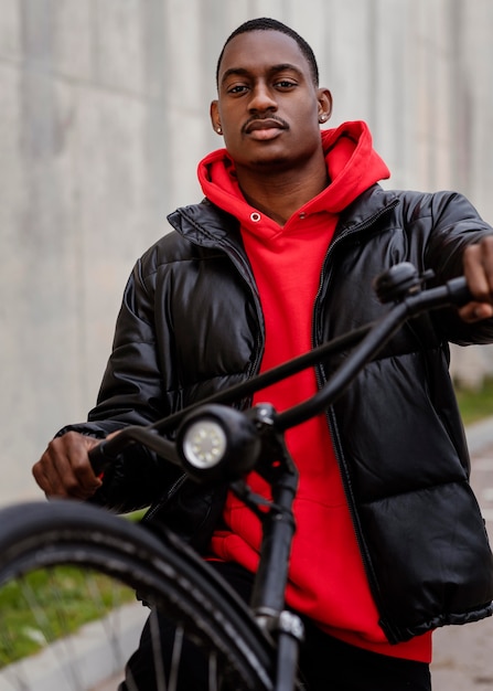 Porträt eines Afroamerikaners und seines Fahrrads