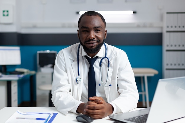 Porträt eines afroamerikanischen Arztes, der im Krankenhausbüro arbeitet