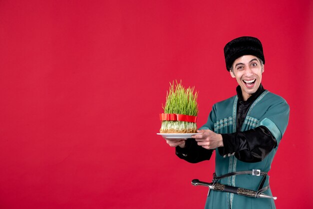Porträt eines aserbaidschanischen Mannes in traditioneller Tracht mit grünem Samen auf Rot