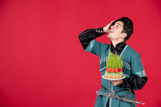 Kostenloses Foto porträt eines aserbaidschanischen mannes in traditioneller tracht mit semeni studio shot red novruz spring concept performer
