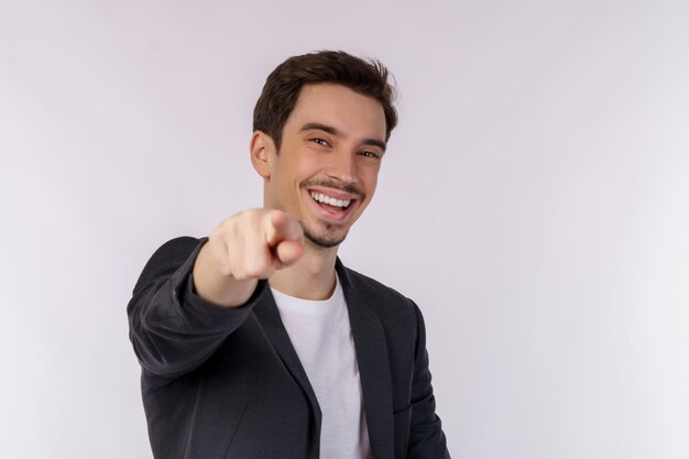 Porträt eines attraktiven, fröhlichen jungen Mannes, der mit dem Finger auf die Kamera zeigt und isoliert über dem Hintergrund steht