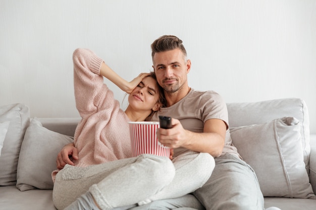 Porträt eines attraktiven jungen Paares, das Popcorn isst