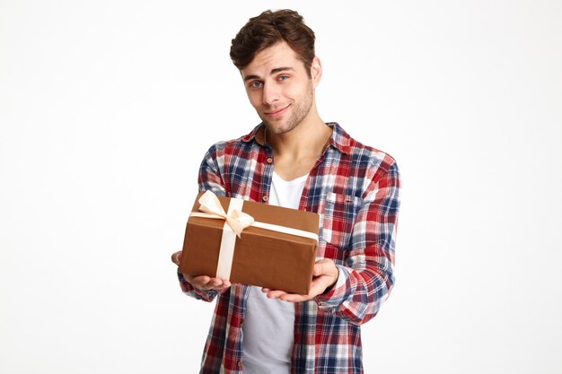 Porträt eines attraktiven lässigen Mannes, der eine Geschenkbox hält