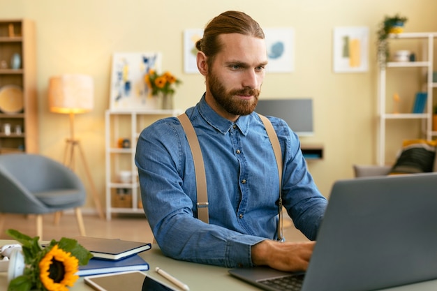 Porträt eines bärtigen Mannes, der am Laptop arbeitet