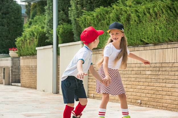 Porträt eines charmanten Teenagerpaares, das zusammen auf Rollschuhen im Park skatet.