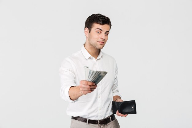 Porträt eines erfolgreichen lächelnden Mannes, der Brieftasche hält