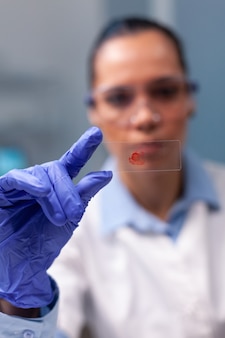 Porträt eines facharztes, der den blutprobentest analysiert, der am genetischen experiment arbeitet