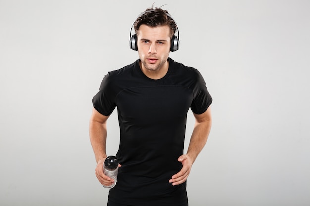Porträt eines fitten jungen Sportlers, der Musik hört