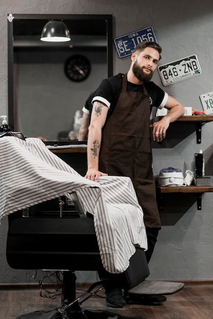 Porträt eines Friseurs, der im Friseursalon steht