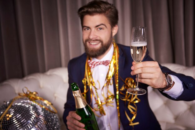 Porträt eines fröhlichen Geschäftsmannes mit Champagnertoasten