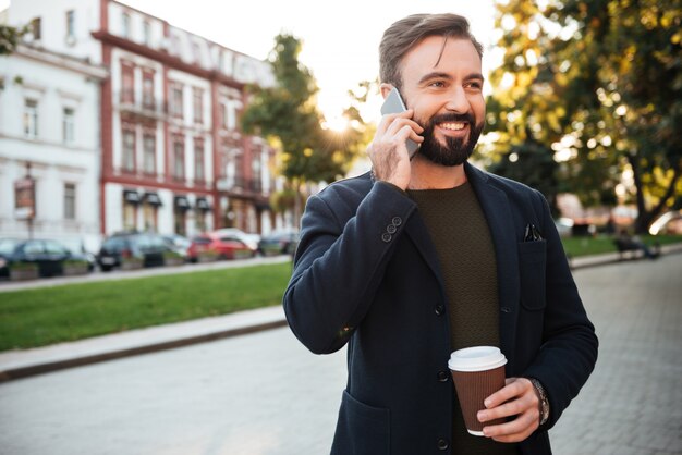 Porträt eines fröhlichen Mannes, der auf Handy spricht