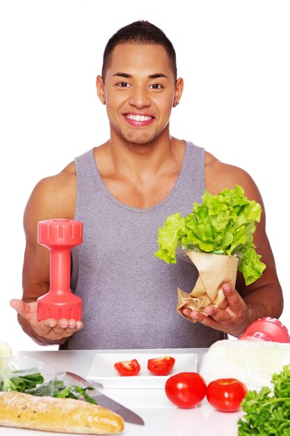 Porträt eines gesunden Mannes, der im Studio mit Salat posiert