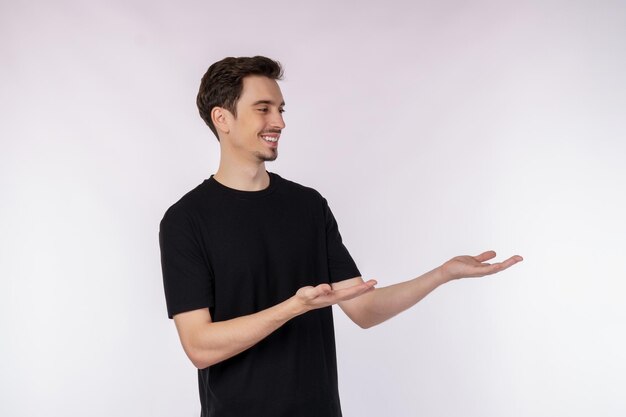 Porträt eines glücklich lächelnden jungen Mannes, der Ihren Text oder Ihr Produkt isoliert auf weißem Hintergrund präsentiert und zeigt