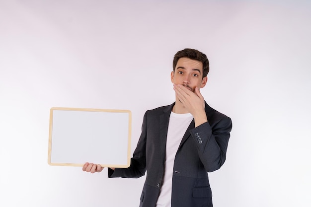 Porträt eines glücklichen Geschäftsmannes, der ein leeres Schild auf isoliertem weißem Hintergrund zeigt