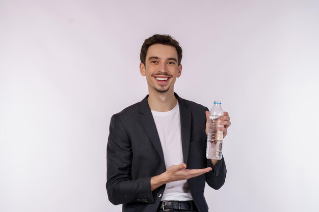 Porträt eines glücklichen jungen Mannes, der Wasser in einer Flasche zeigt, die über weißem Hintergrund isoliert ist