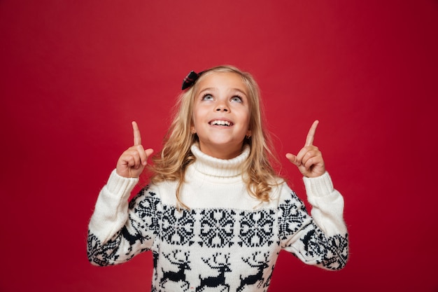Porträt eines glücklichen kleinen Mädchens im Weihnachtspullover