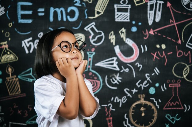 Porträt eines glücklichen kleinen Schulkindes mit Brille