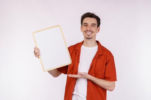 Porträt eines glücklichen Mannes, der ein leeres Schild auf isoliertem weißem Hintergrund zeigt