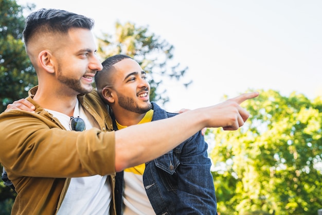 Porträt eines glücklichen schwulen Paares, das Zeit zusammen verbringt und ein Date im Park hat. Lgbt und Liebeskonzept.