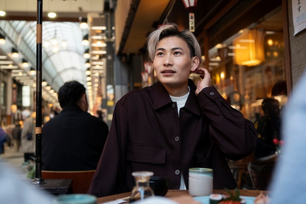 Kostenloses Foto porträt eines gutaussehenden asiatischen mannes bei einem wiedersehen mit freunden