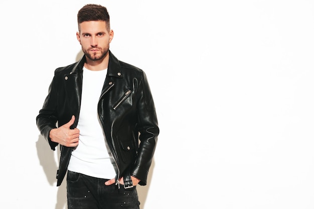 Porträt eines gutaussehenden, selbstbewussten Modells Sexy stilvoller Mann in Biker-Lederjacke und schwarzer Jeans Mode-Hipster-Mann isoliert auf Weiß im Studio