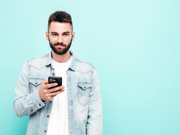 Porträt eines gutaussehenden, selbstbewussten Modells. Sexy, stilvoller Mann Mode-Hipster-Mann posiert in der Nähe einer Wand im Studio