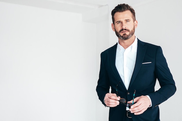Porträt eines gutaussehenden, selbstbewussten, stilvollen Hipster-Lambersexual-Modells Sexy moderner Mann in schwarzem, elegantem Anzug Modemann, der im Studio auf weißem Hintergrund posiert