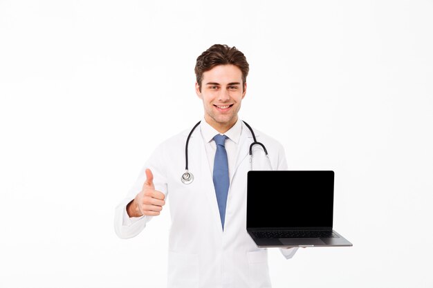 Porträt eines heitren jungen männlichen Doktors mit Stethoskop