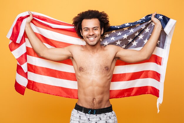 Porträt eines hemdlosen afroamerikanischen Mannes, der USA-Flagge hält