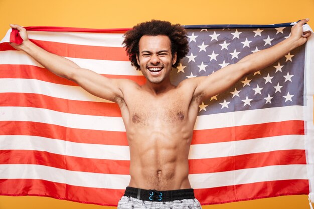 Porträt eines hemdlosen afroamerikanischen Mannes, der USA-Flagge hält