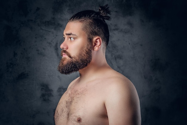 Porträt eines hemdlosen, fetten, bärtigen Mannes auf grauem Hintergrund.