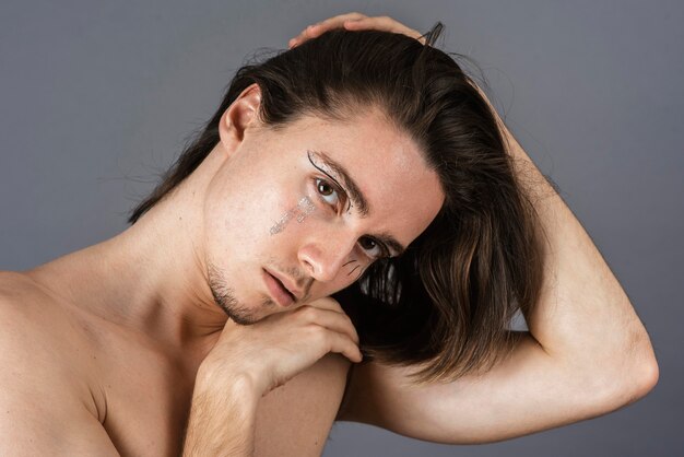 Kostenloses Foto porträt eines hemdlosen mannes mit make-up