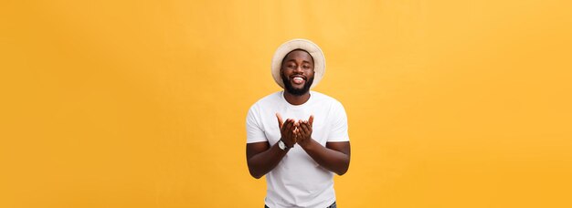 Porträt eines hübschen jungen Afrikaners, der im weißen T-Shirt auf gelbem Hintergrund lächelt