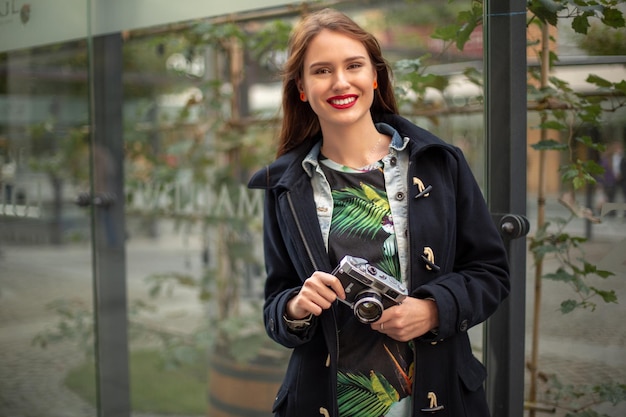 Porträt eines hübschen jungen Touristen, der mit einer alten Retro-Kamera fotografiert. Streetstyle. Lebensstil