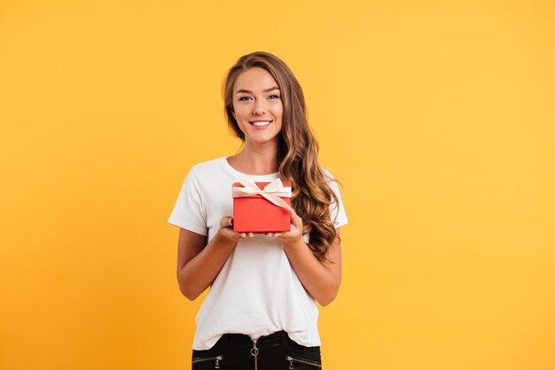 Porträt eines hübschen lächelnden Mädchens, das Geschenkbox hält