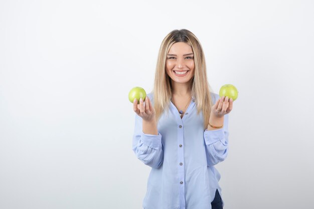 Porträt eines hübschen Mädchenmodells, das frische Äpfel steht und hält.