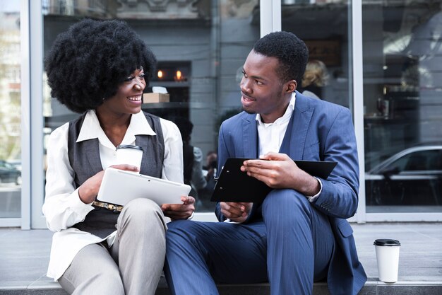 Porträt eines jungen afrikanischen Geschäftsmannes und der Geschäftsfrau, die eine Büropause machen