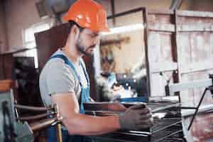 Kostenloses Foto porträt eines jungen arbeiters in einem schutzhelm in einer großen abfallrecyclingfabrik.