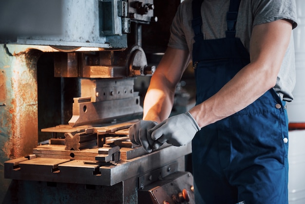 Porträt eines jungen Arbeiters in einem Schutzhelm in einer großen Metallbearbeitungsanlage.