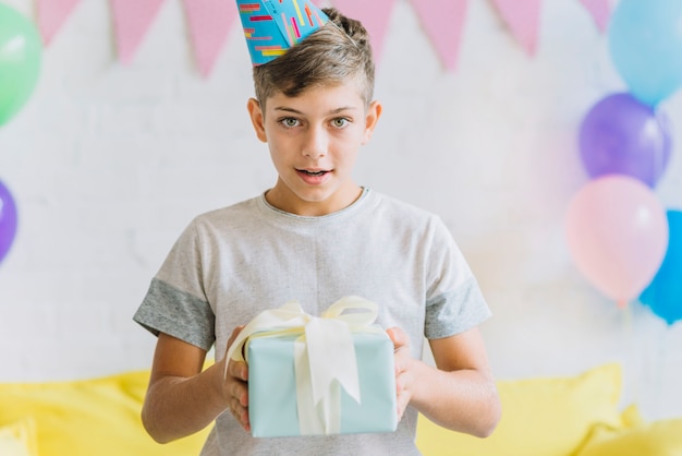 Porträt eines Jungen, der Geburtstagsgeschenk hält