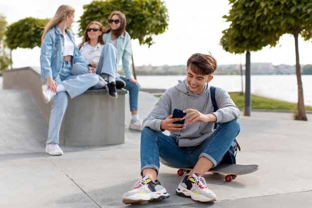 Porträt eines Jungen, der neben seinen Freunden ein Skateboard hält