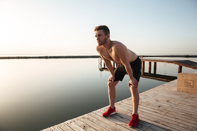 Porträt eines jungen gesunden Sportlers, der nach dem Joggen im Freien ruht