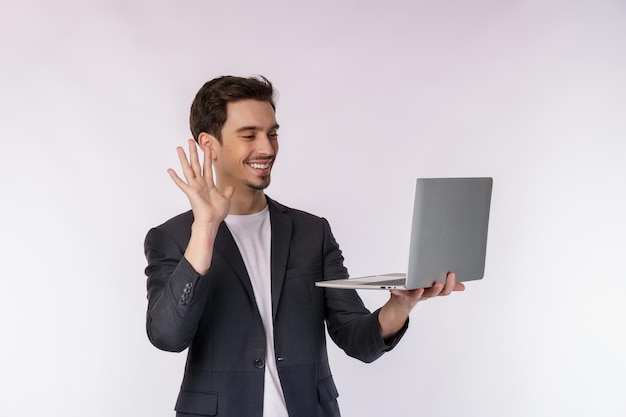 Porträt eines jungen gutaussehenden lächelnden Geschäftsmannes per Videoanruf über Laptop in den Händen isoliert auf weißem Hintergrund