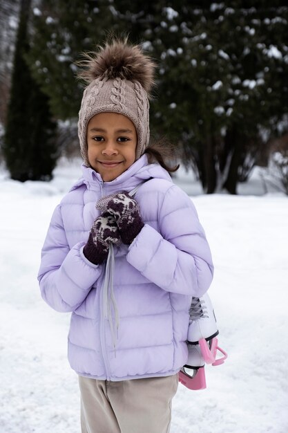 Porträt eines jungen Mädchens mit Schlittschuhen im Freien im Winter