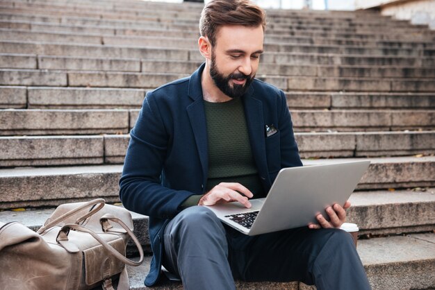 Porträt eines jungen Mannes, der am Laptop arbeitet